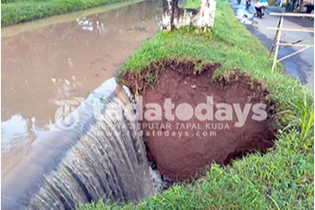 Banjir Bikin Tanah Pembatas Sungai dengan Jalan Berlubang